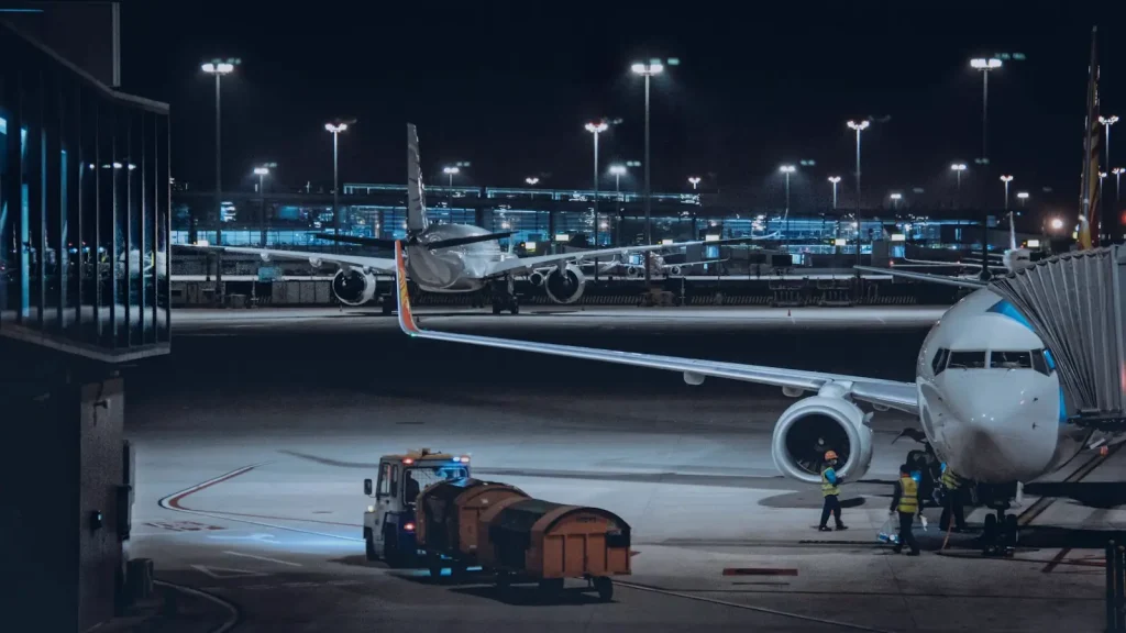 Aircraft being loaded at an airport stand at night